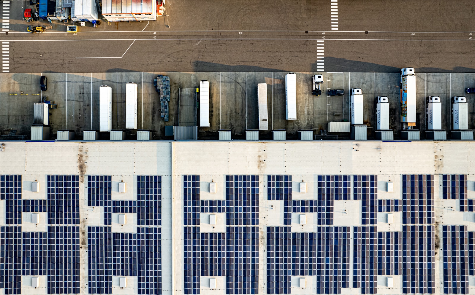 commercial solar panels on warehouse rooftop - aerial view of large-scale solar installation by Raya Solar